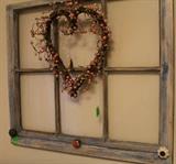 Old window distressed paint with heart wreath and knobs for hanging items.