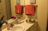 Coral hand towels in bathroom with accessories.