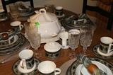 Close-up of china on kitchen table along with crystal wine and water glasses.