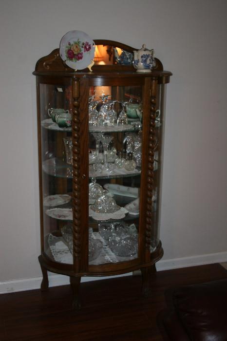 Antique oak curve front cabinet with glass shelves, cut crystal & glass serving pieces