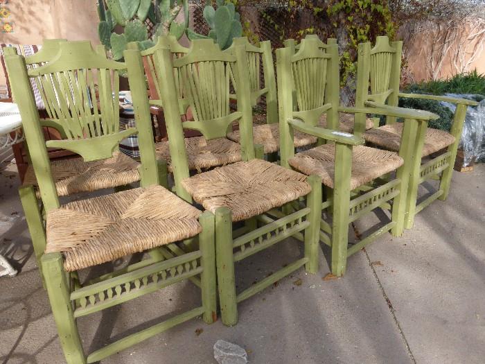 8 green chairs with rattan seats.