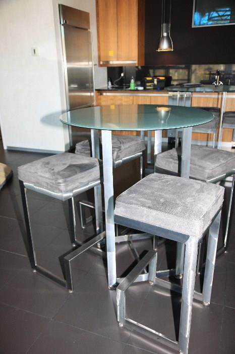 There are three of these ultra modern, yet very practical bar tables and stools of glass, aluminum and micro fiber.  Would be great inside or out.