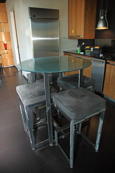 Three tall tables with four chairs each, green tinted glass, grey suade chairs, chrome.