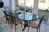 Black Wrought Iron oval dining table with 1/2" glass top from The Great Outdoors.  Seats up to 10 persons.  Comes with six designer wrought iron chairs with neutral color fabric seats.