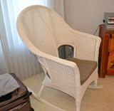 High back rattan rocking chair with padded seat.