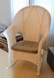 High back rattan rocking chair with padded seat.
