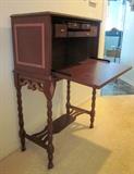 Antique drop-front writing desk, with drawers, spindle legs and small fretwork shelf.  Has been painted and mirror applied inside.