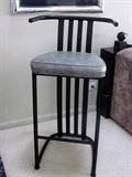 Set of four barstools with black metal frames and gray cushion seats.
