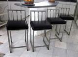 Set of four kitchen counter stools with stainless steel frames and black cushion seats.
