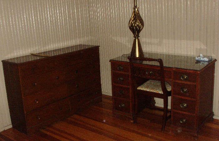 chest of drawers and desk with large brass lamp