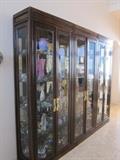 Three mahogany finish interior-lighted curio cabinets with beveled glass doors