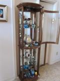 Curved glass curio cabinet with lighted interior