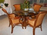 Rattan dining set.  Includes 4 chairs and round glass top table.