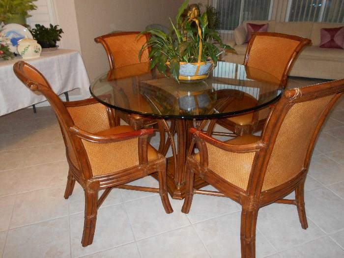Rattan dining set.  Includes 4 chairs and round glass top table.