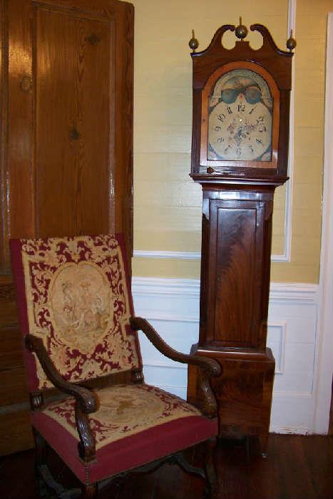 English grandfather clock in mahogony. The clock is in very good condition - it runs and keeps time.  The clock dates to the mid to late 1800's. The needlepoint chair is English - needlepoint is in very good condition and it dates to 1910-1920