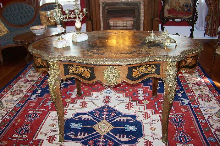 Beautiful French marquetry table with gilt brass trim and a center drawer.  The piece dates to 1880-1900
