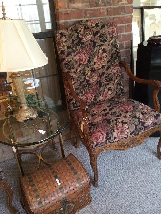 One of two armed upholstered chairs; glass top end table & another lamp