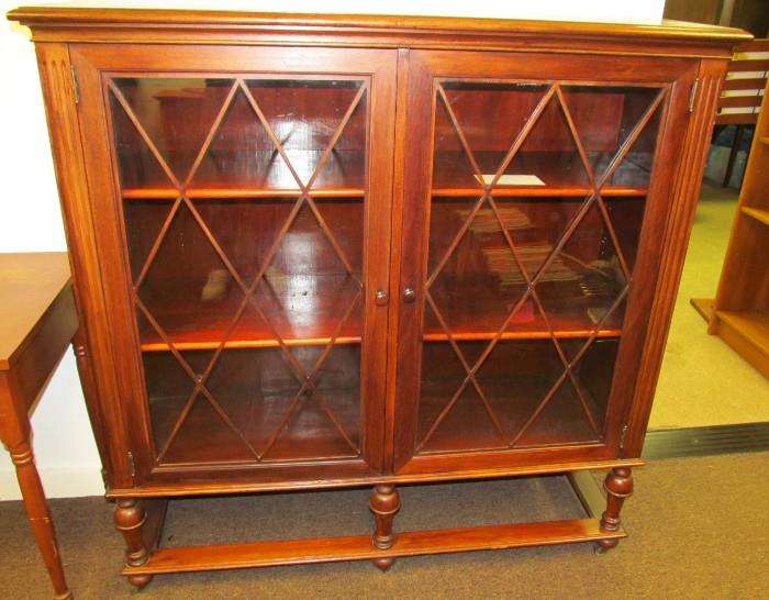 Mahogany 2 door bookcase with 4 adjustable 1/2 shelves on casters. 49 1/2" High X 48 1/2" Wide by 15" Deep.