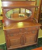 Oak sideboard with mirrored gallery, 2 drawers over 1 and 2 doors on bottom. Very heavy & very ornate. 66 1/2" High X 48" Wide X 22" Deep.