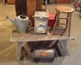 Rustic wooden bench/table with galvanized watering can, old tin cracker box, painted stool & vintage Acme air storage tank (sounds like something from an old Road Runner cartoon, no?)