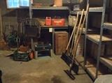 Hose reel, newer Scotts push mower with grass bag, plastic garden stool, old wooden crates, Evinrude "Cruis-a-Day" red metal gas can, snow shovels & yard tools 