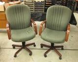 Two office chairs. green fabric, oak arms and base, rolling, tilts (height adjustment sticks).