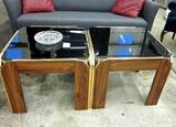 Two 24" square end tables. Black glass tops with wood bases and goldtone trim. Can be used together as a coffee table or seperately as end tables.