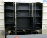Black 3-section wall unit with glass doors and goldtone trim. Area for TV and entertainment components, 5 lighted display areas and lots of bottom storage. Overal dimensions 71" w x 78" h.