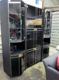 Black 3-section wall unit with glass doors and goldtone trim. Area for TV and entertainment components, 5 lighted display areas and lots of bottom storage. Overal dimensions 71" w x 78" h.