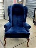 Large wing-back chair, dark blue velour fabric.