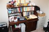 Desk with misc. office items, books, and 2-drawer filing cabinet