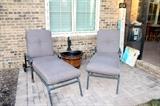 Outdoor metal chaise lounge chairs, patio umbrella and stand, and bucket fountain