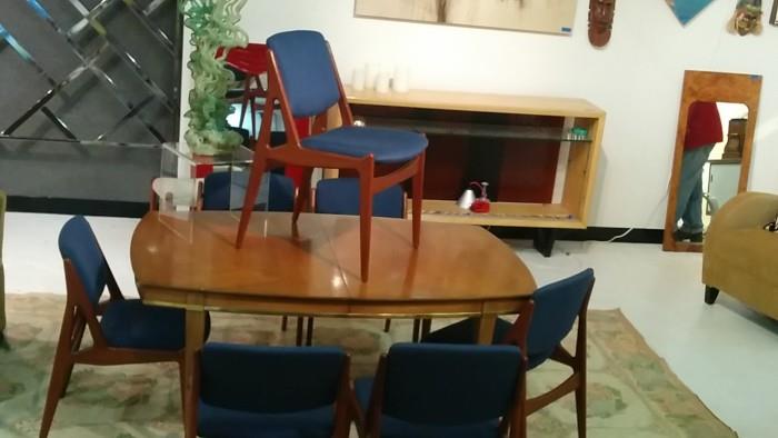 9 x 12 chainstitched wool rug, topped by a sassy dining table and set of 8 Arne Vodder swivel back chairs.