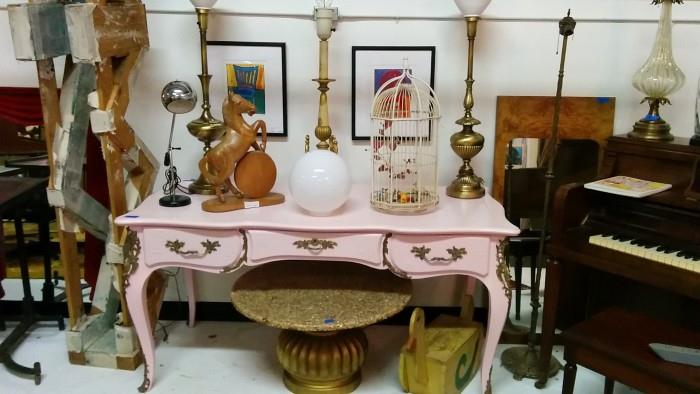 Wow - a visual feast (famine?) of overstimulation. Take one pink over-sprayed Chinoiserie desk, add hand-carved wooden horse, three brass table lamps, a black/chrome desk lamp, a birdcage and Grandpa's- homemade-woodworking-project-gone-wrong duck and you have a recipe for disaster!