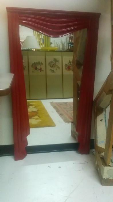 Umm, a red wooden mirror with carved curtain detailing, but why? 