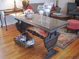 Glass topped trestle style table with classical and dolphin details.