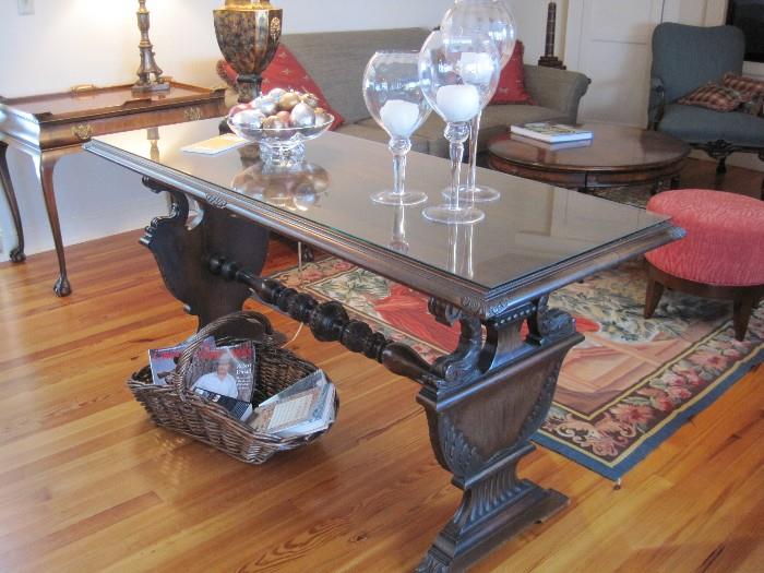 Glass topped trestle style table with classical and dolphin details.