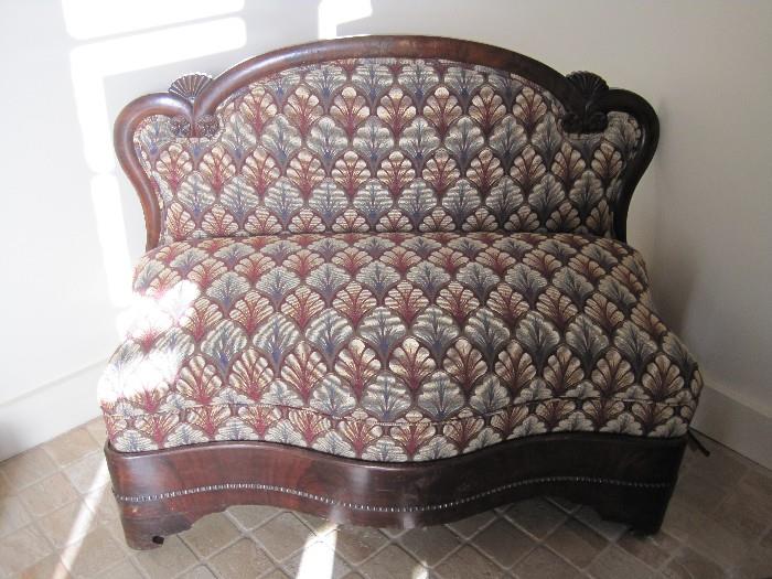 Antique love-seat with shell design and serpentine front.