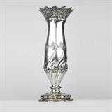 1026  A sterling silver table vase, Tiffany & Co.
Circa 1895, with maker's mark for directorship of Charles L. Tiffany, marked ''Tiffany & Co. / 12321 Makers 7293 / Sterling Silver / 925-1000 / T'', the wide, crenellated mouth chased to interior with stylized waves, tapering to a baluster-form body all-over repousse-decorated with stylized waves, kelp, and pneumatocysts, over a waisted base with a waved socle, supported on a stepped circular foot, 18.25'' H x 7.25'' Dia., 59.345 oz troy approximately, est: $2000/3000

Provenance: Private Collection, Pasadena, CA.  Condition: Overall good condition. General marks, scratches, and tarnishing commensurate with age. Some tips of waves at mouth bent slightly in or outward. One side of foot slightly out of shape; does not stand perfectly flush on a flat surface.  Your bid indicates acceptance of our Conditions of Sale.  AS-IS.  ALL SALES FINAL