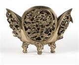 1095  A Chinese gilt metal jardiniere
Late 19th / early 20th century, the oblong pierced quatrefoil body decorated with dragons, birds, snakes and twisting foliage, raised on four demon-headed ball and claw feet, with liner, 14.25'' H x 20.5'' W x 15'' D, est: $400/600

Provenance: Private Collection, La Jolla, CA.  Condition: Overall good condition. General marks, scratches and rubbed wear commensurate with age and use. Scattered minor chips and losses, including loss of peacock's crest and scattered losses to gilding at upper borders.  Your bid indicates acceptance of our Conditions of Sale.  AS-IS.  ALL SALES FINAL