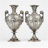 1146  A pair of Neoclassical silver plate vases, Elkington & Co.
Late 19th / early 20th century, each signed to underside ''Published By / 1478 / Elkington & Co.'' within an applied oval, each with a flared rim over a tapering neck above an urn-form body repousse-decorated with scenes depicting the birth of Venus to one face and the punishment of Cupid to the other, flanked by scroll handles issuing from female portrait medallions, supported overall by a waisted two-tiered spreading circular foot, 2 pieces, 9.5'' H x 5'' W x 4.5'' D, est: $500/700

Provenance: Private Collection, Tujunga, CA.  Condition: Overall good condition. General marks, scratches, tarnishing, and rubbed wear commensurate with age. Remnants of polish throughout. A few scattered minute dings to each.  Your bid indicates acceptance of our Conditions of Sale.  AS-IS.  ALL SALES FINAL