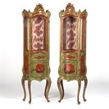 1165  A pair of Italian carved Rococo-style Chinoiserie vitrine cabinets
Mid-19th century, each polychrome and gilt painted, with a pierced rocaille crest above a locking glazed door enclosing a silk-lined interior with one shelf, over a bombe body decorated to each side with a painted red-ground Chinoiserie reserve, faced with a single drawer over a cabinet door centering a third Chinoiserie reserve enclosing a fabric-bottomed interior, raised on four cabriole legs, 2 pieces, the first: 69'' H x 20.5'' W x 12.5'' D; the second: 68.5'' H x 20.5'' W x 12'' D, est: $4000/6000

Provenance: Private Collection, La Jolla, CA.  Condition: Lacking keys. Each lacking one shelf. Each with scattered evidence of insect damage. Structurally sound, with general marks, scratches, nicks and shrinkage cracks commensurate with age. Fabric lining worn. The first: a 5.5''-long horizontal crack to lower left side of one glazed panel. A 1.5'' split to upper right side panel. Door and right side glass panels