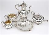 1238  A Victorian sterling silver coffee and tea service, Joseph & Albert Savory
1843 - 1847, London, maker's marks of Joseph & Albert Savory, the coffee pot, milk jug, and sugar bowl further marked ''2'', the teapot further marked ''1'', a five piece set comprising: a coffee pot (10.5'' H x 9.5'' W x 6.5'' D), a tea pot (5.75'' H x 11.5'' W x 6.75'' D), a sugar bowl with gilt interior (4.5'' H x 8.25'' W x 6'' D), and a milk jug with gilt interior (5'' H x 6.5'' W x 4.75'' D), the hinged lidded articles with leaf and pumpkin finials, each of squat gourd-form with scrolling handles, raised on four scroll feet, each inscribed to one face ''Presented To / The Rev.d Edward Forbes, B.A. / by / the Parishioners of / Ramsey, /13, September, 1847.'', together with a three-footed serving tray (1.5'' H x 10'' Dia.) inscribed ''Presented / to / The Rev.d Edward Forbes, B.A. / by the / Parishioners Of Ramsey, / (with a Tea Service) / as a small token of their esteem & of the high respect they ent