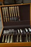 Flatware set trimmed in gold in a lovely wooden box.