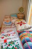 Vintage quilts, vintage aprons, doilies and sewing basket.