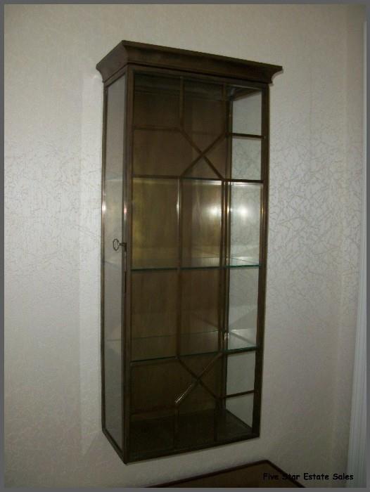A brass and glass wall display case - about 3 feet tall.