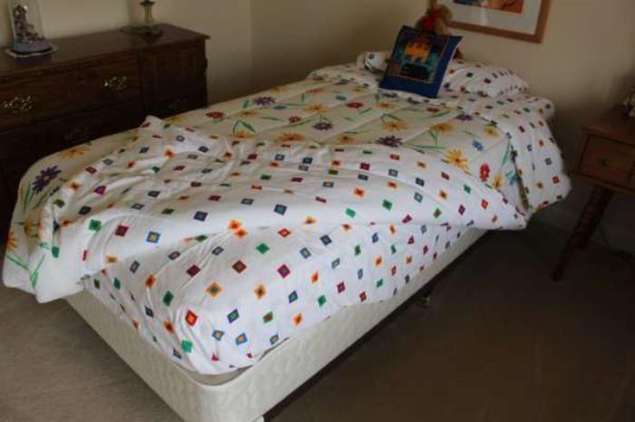 Two twin beds and matching/reversible comforter sets: colorful flowers on one side with geometric pattern on the other.
