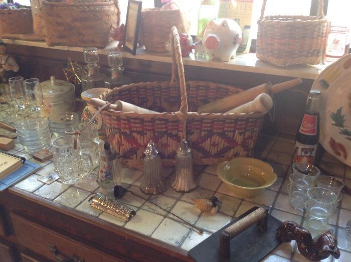 large old Choctaw basket with others in background. old rolling pins and kitchenware