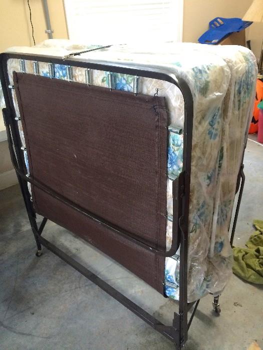 Metal-frame foldaway bed with mattress in original plastic, never used