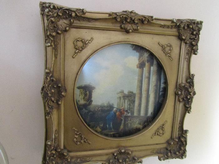 Unusual circular frame with foliate edges framing an antique scene.